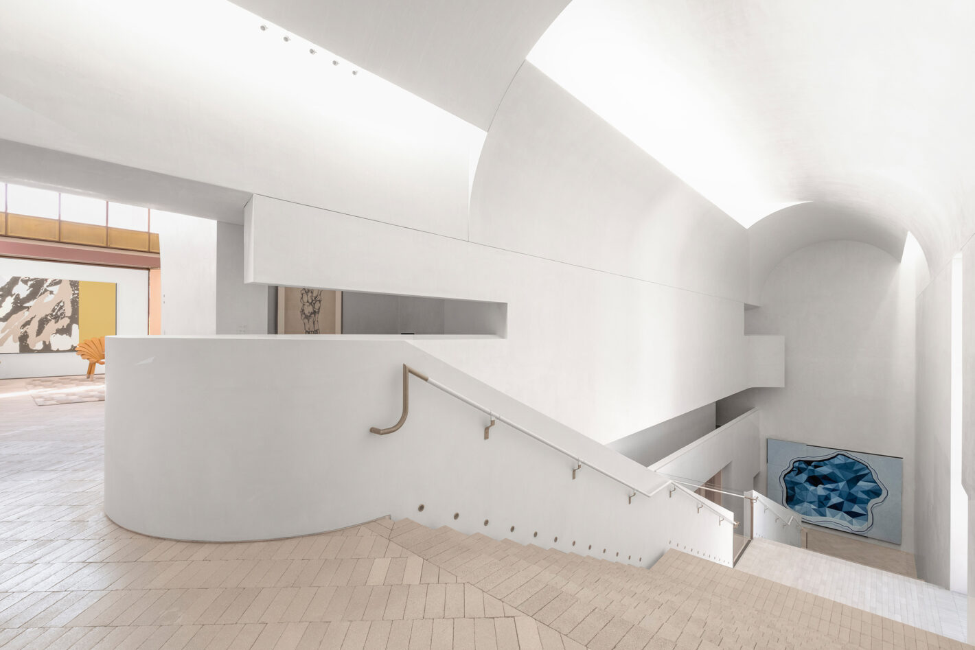 Cavernous stair hall of Indigo Slam, illuminated by concealed roof lights, featuring minimalist design elements and expansive space.
