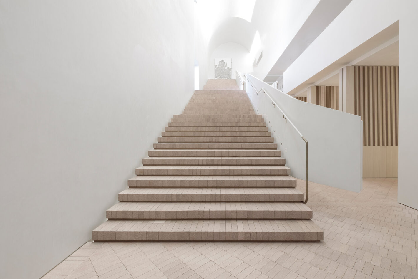 Cavernous stair hall of Indigo Slam, illuminated by concealed roof lights, featuring minimalist design elements and expansive space.